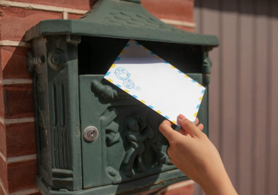 mailbox with hand holding envelope
