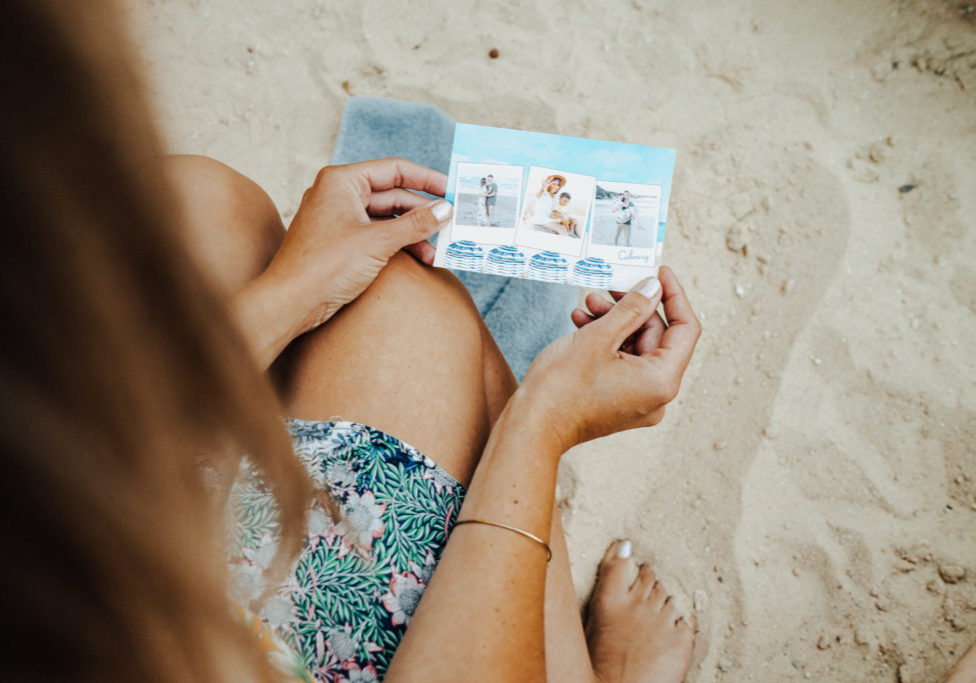 femme regardant carte cabourg dans sable