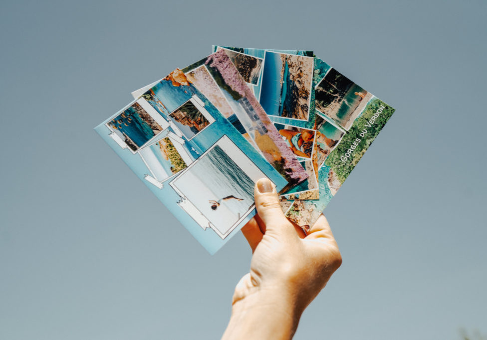 Hand mit Fan von Postkarten aus dem Verdon