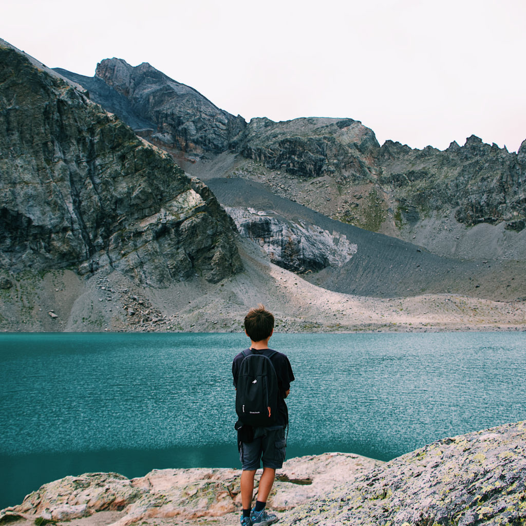 boy in front of the lake of the ecrins park