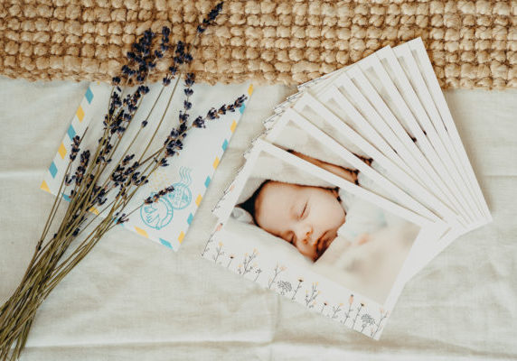 stack of baby announcements with sprig of lavender