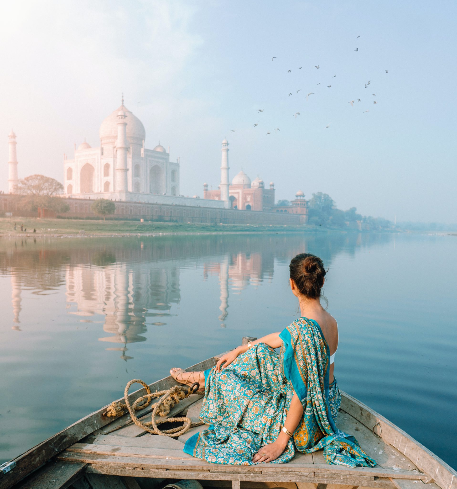 woman on boat in front of taj mahal