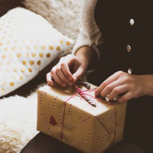 Weihnachtsgeschenk auf dem Schoß einer Frau