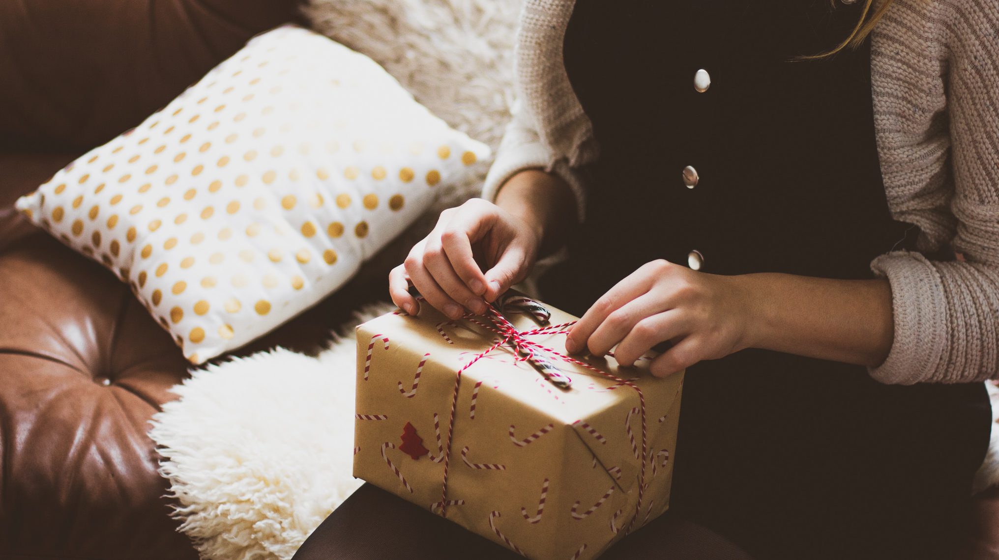 Weihnachtsgeschenk auf dem Schoß einer Frau