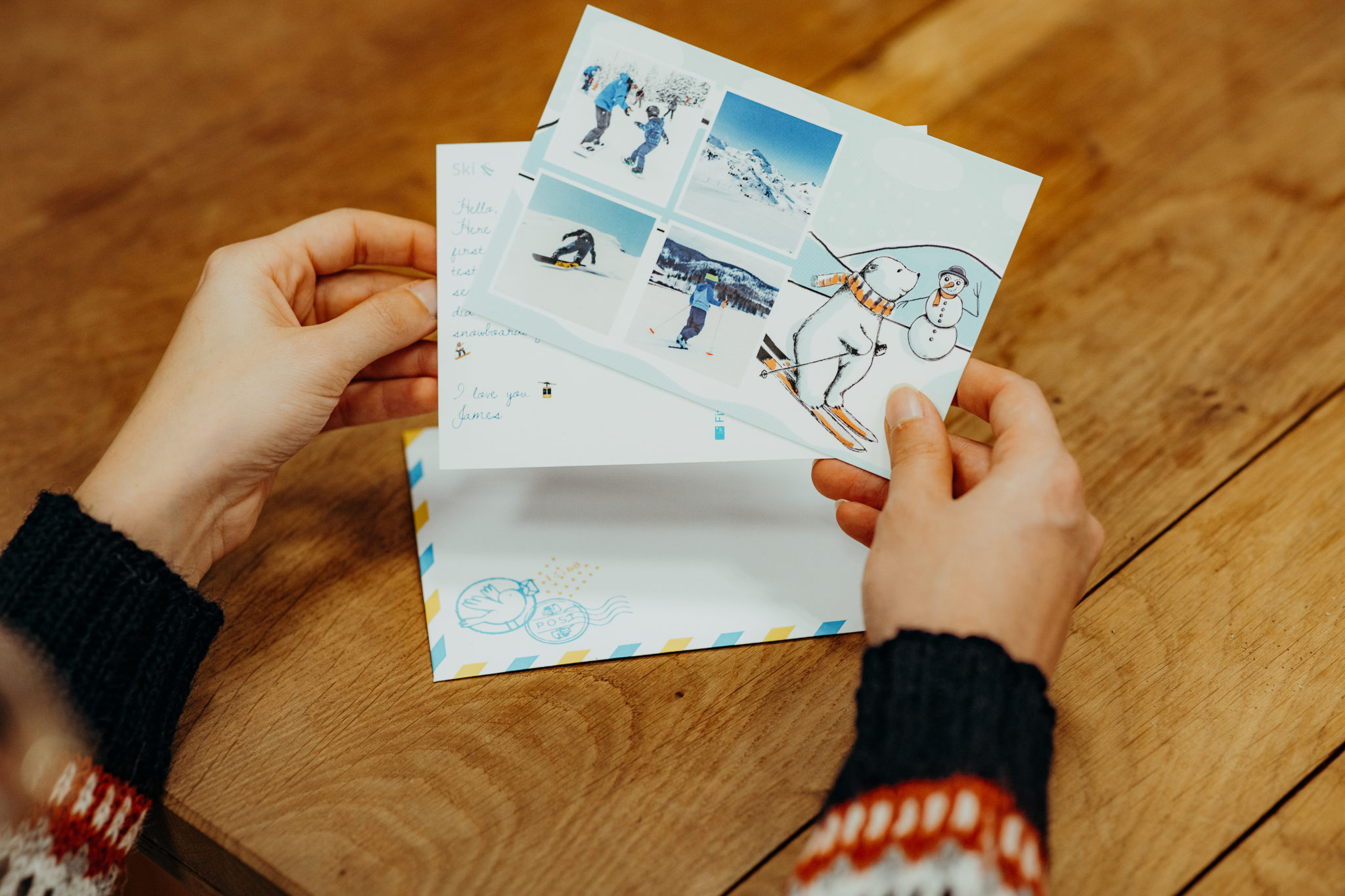hands holding card with teddy bear skiing
