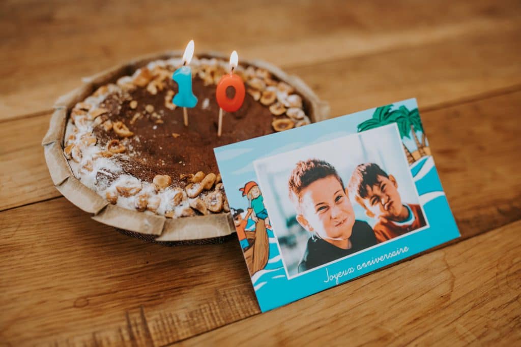 carte anniversaire enfant devant gâteau au chocolat