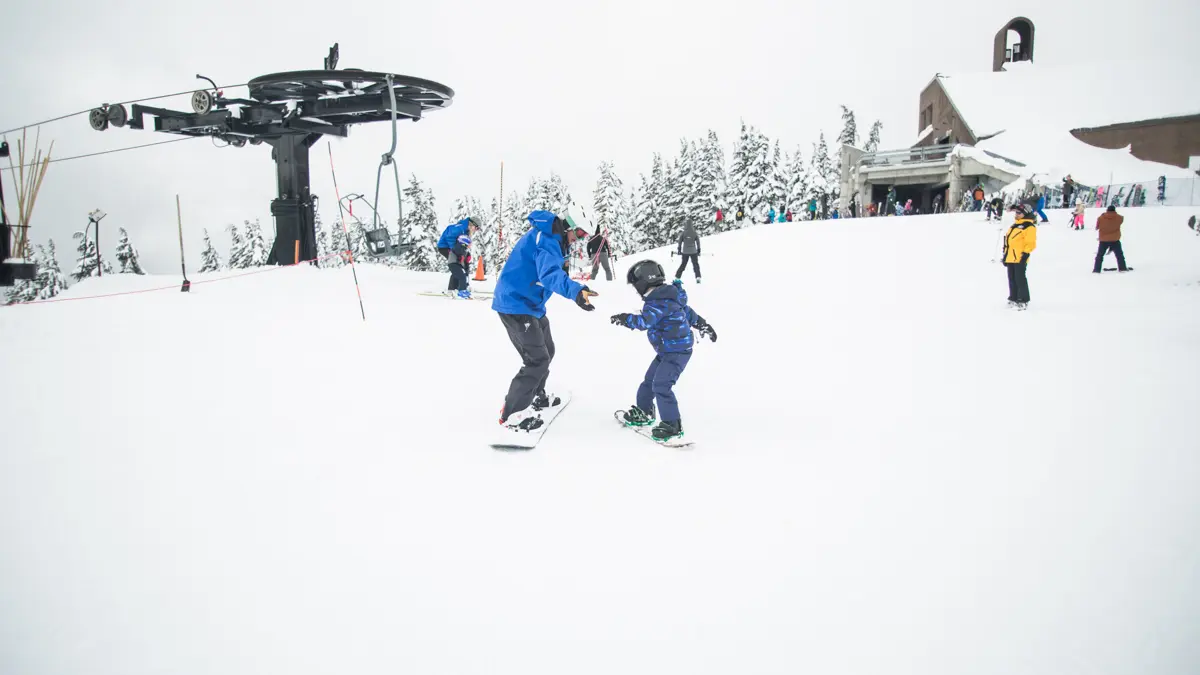 Erste Schritte Kind auf dem Snowboard