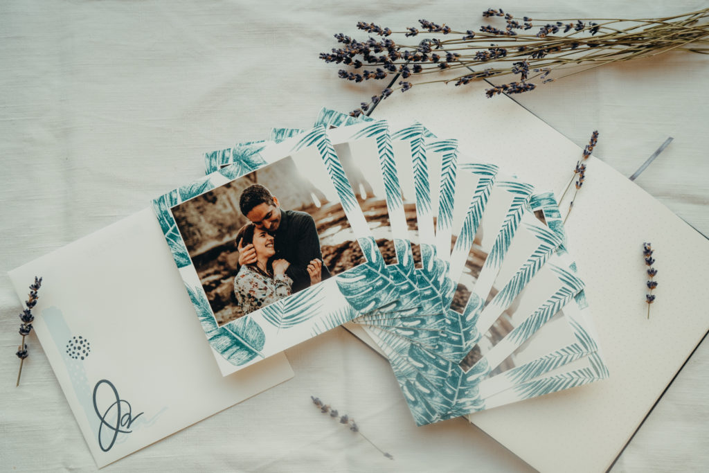 pile de faire-part avec couple et feuilles de monstera