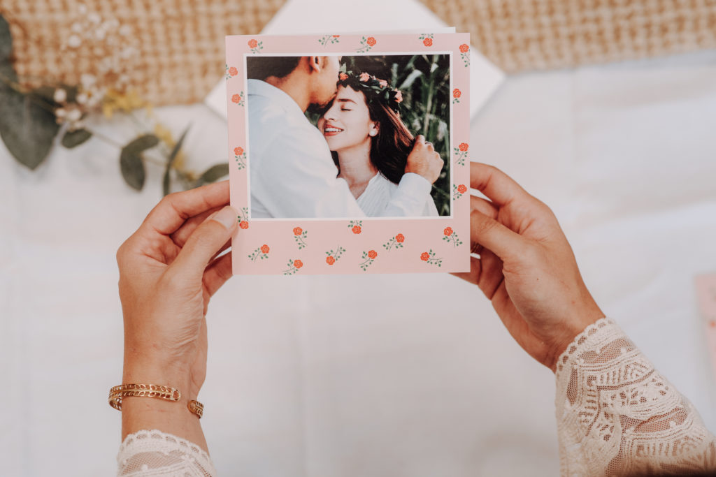 hands holding a flowery rose announcement