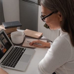 Frau in Videokonferenz auf Laptop