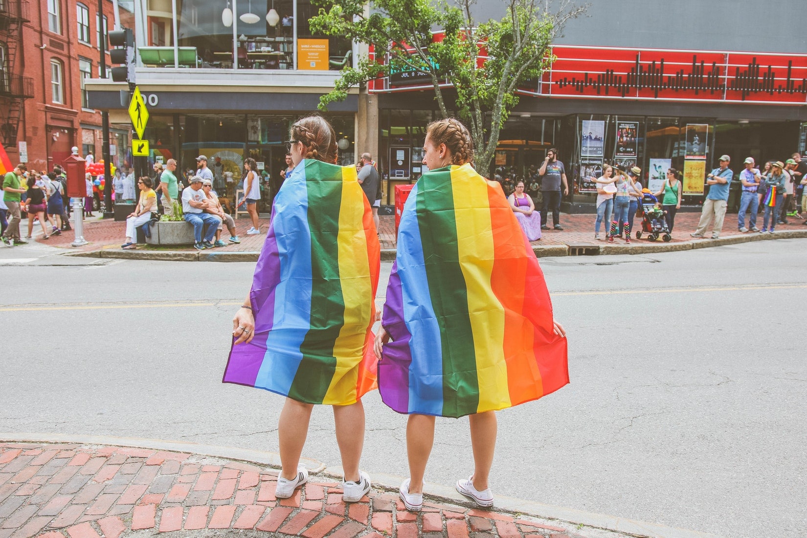 Zwei Frauen tragen eine Regenbogenfahne für Gay Pride.