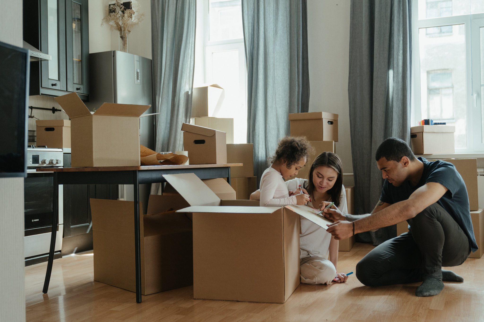 famille qui deballe ses cartons de demenagement