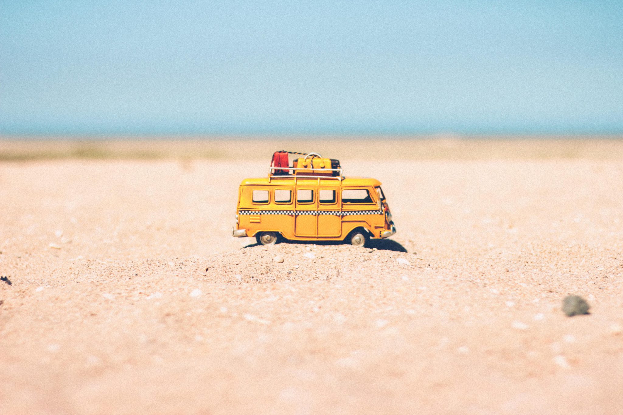 Gelber Kombi-Van im Sandurlaub am Meer