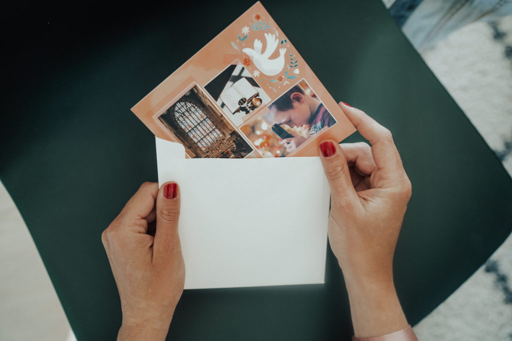 hands coming out card from envelope with dove