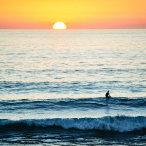 Surfeur sur le spot de surf de Hossegor en France au coucher du soleil