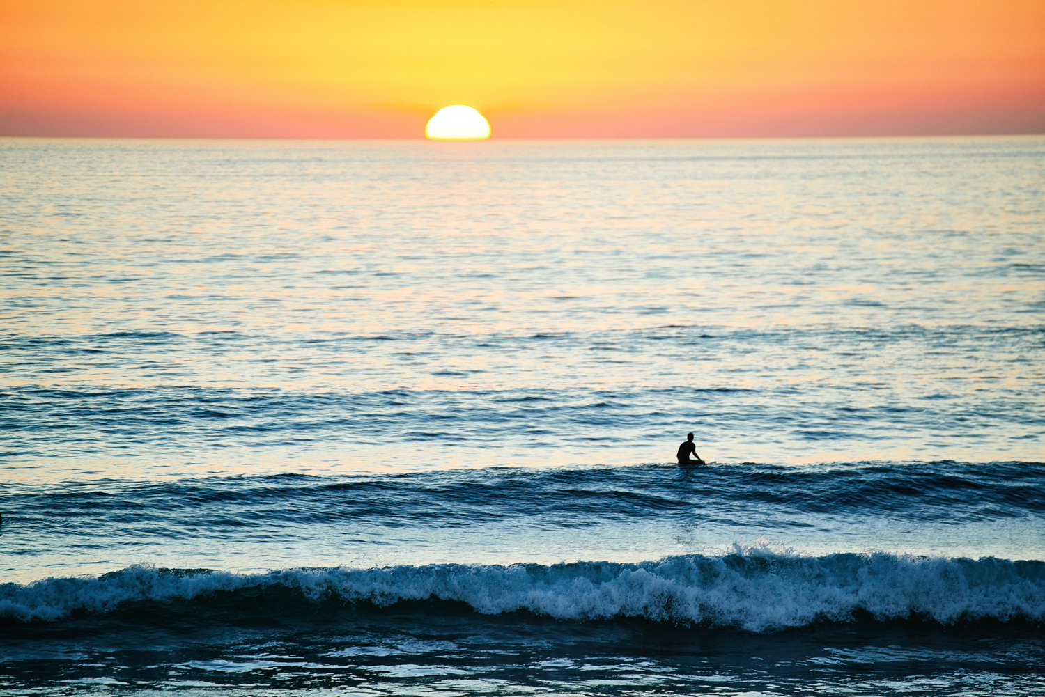 Surfeur sur le spot de surf de Hossegor en France au coucher du soleil