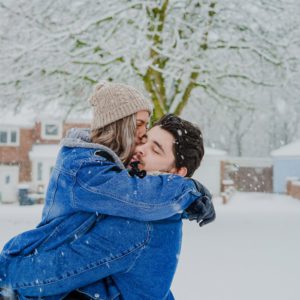Frau wirft sich im Schnee in die Arme ihres Geliebten, eine wunderschöne Liebeserklärung an ihn