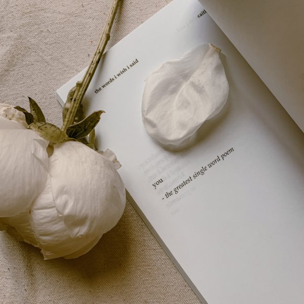 Weiße Rose neben einem Blatt, auf dem ein Vatertagsgedicht geschrieben ist