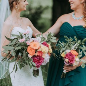 mariée avec sa témoin de mariage tenant des bouquets de fleurs colorées