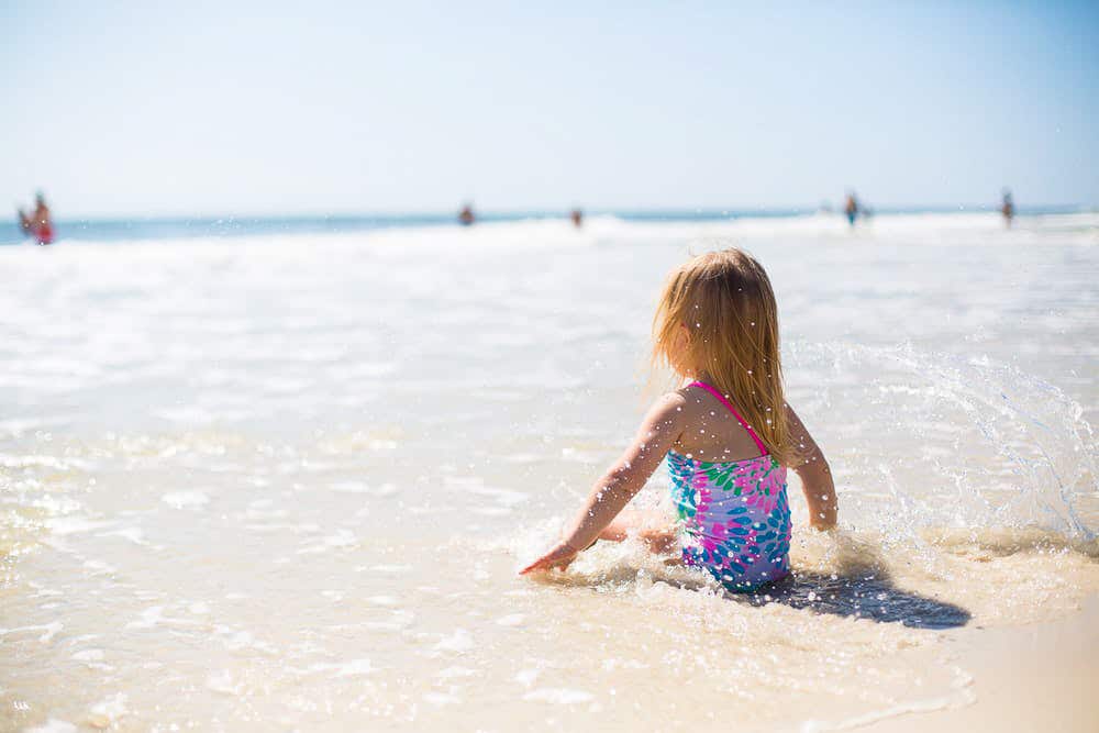 Enfant au bord de l'eau pendant ses vacances à la mer